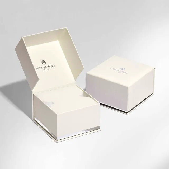 Two white jewelry boxes with 'Nomination' branding on a light gray background