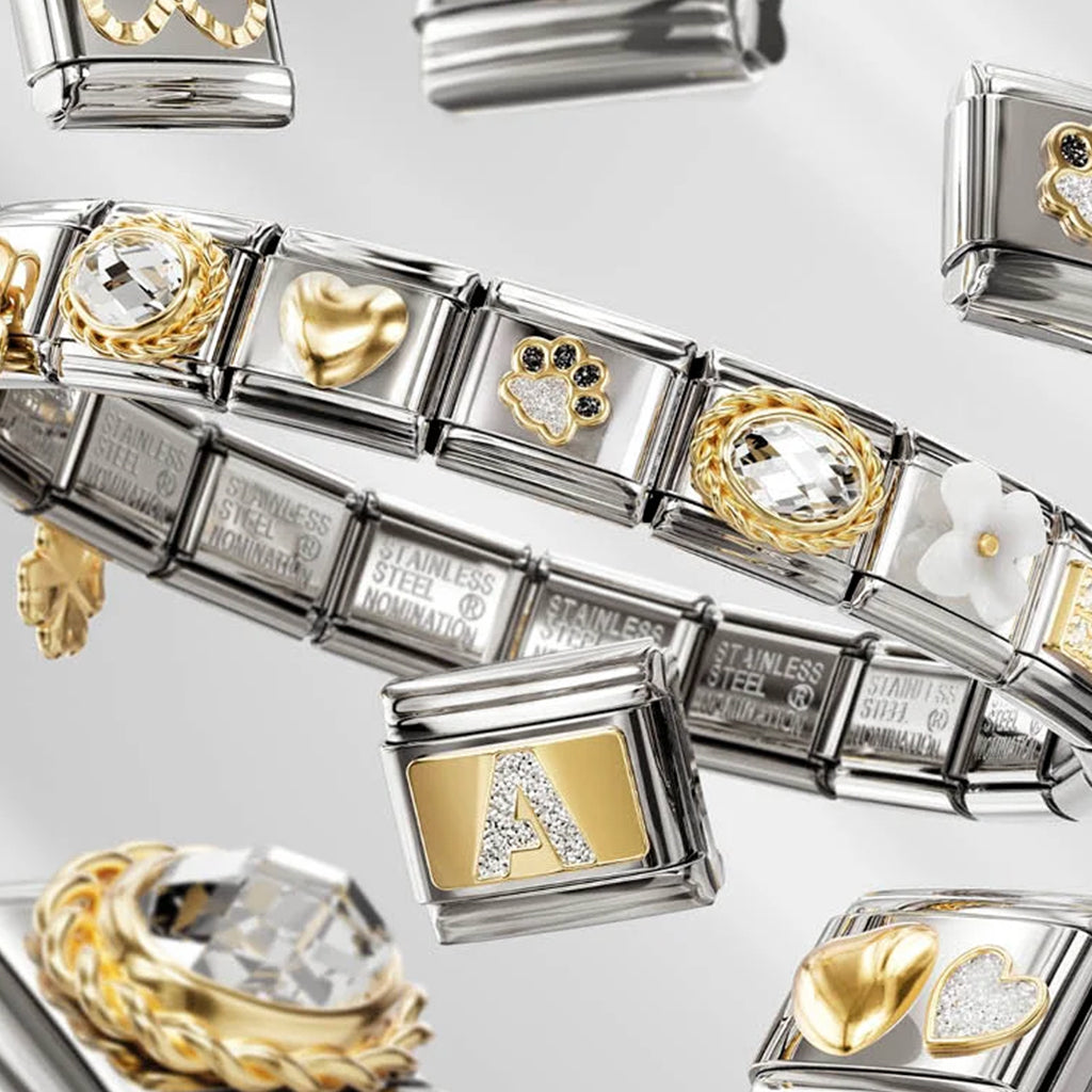 Bracelet with various charms including hearts and letters on a light gray background