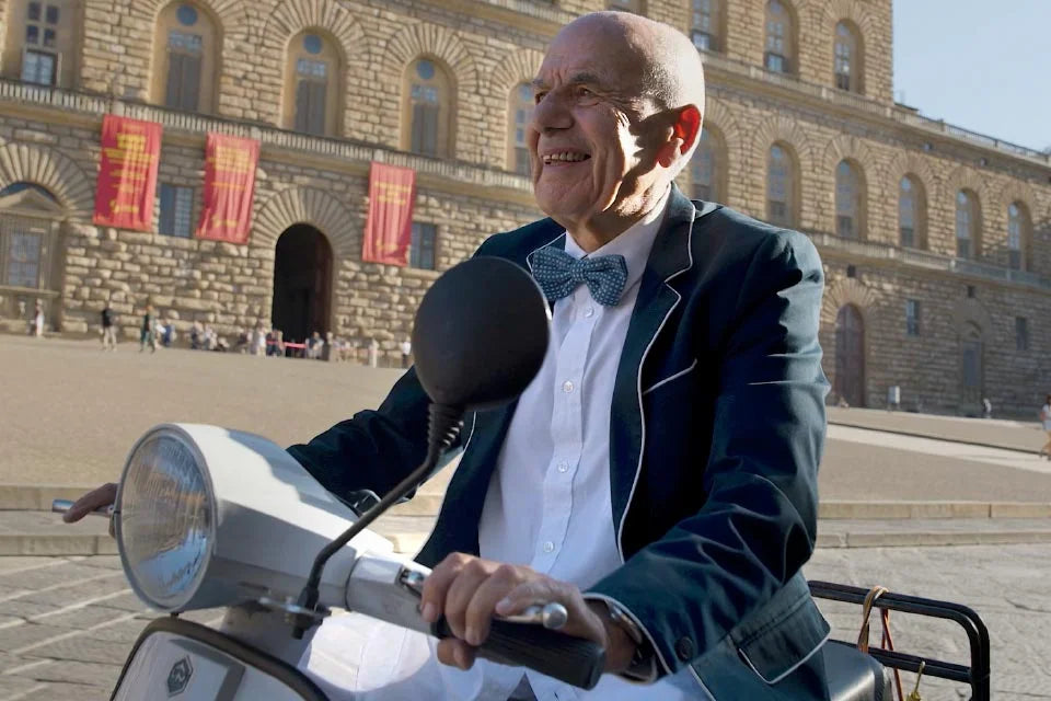 Paolo Gensini the founder of Nomination Italy riding a Vespa through Florence. 