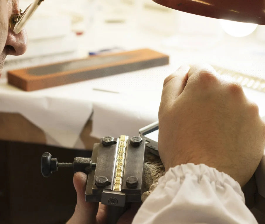 Person working with jewelry tools on a table